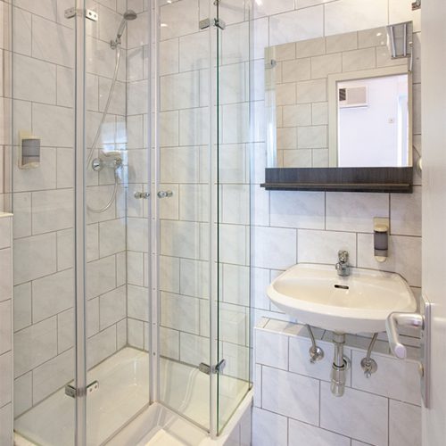 Bad mit Dusche, Spiegel und Waschbecken